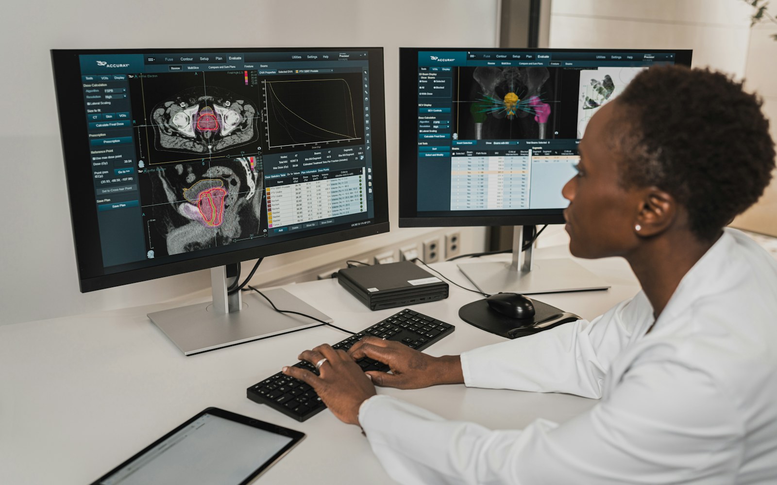 A clinician working in health software across two monitors.